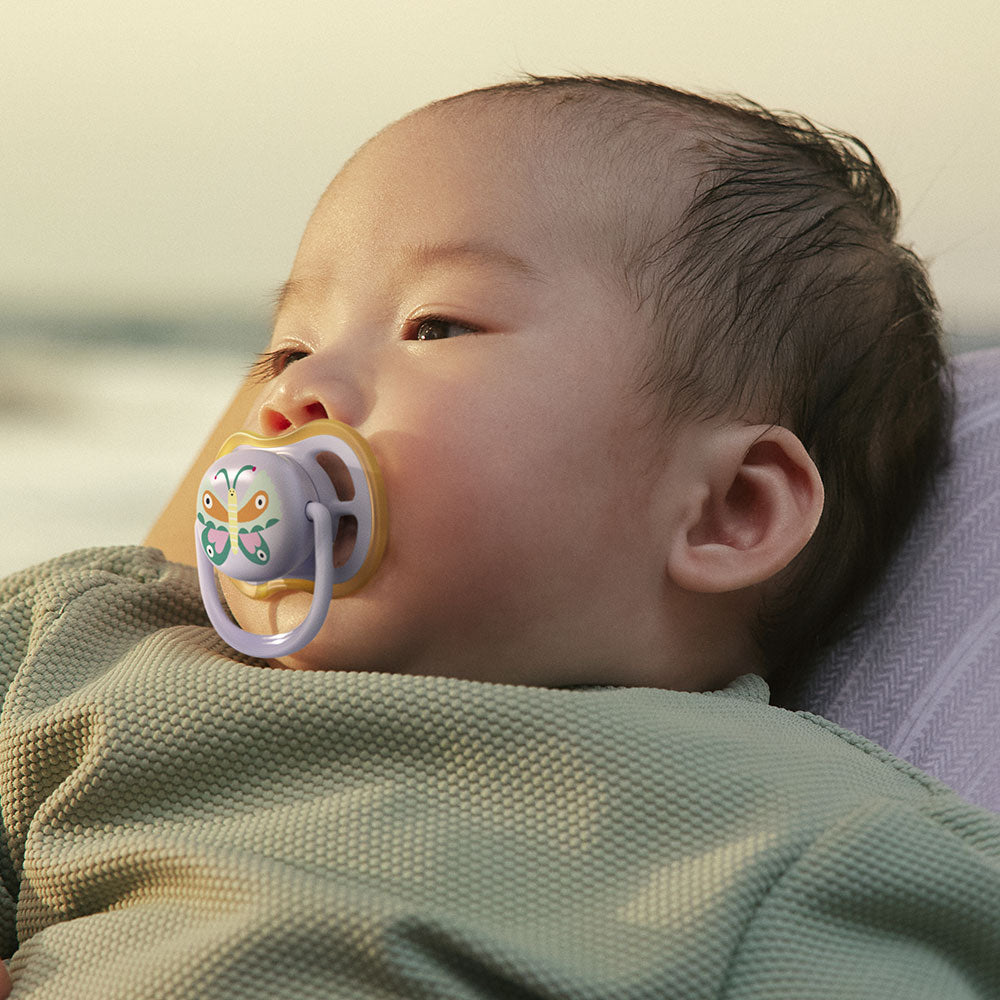 2 броя ортодонтски силиконови залъгалки Philips AVENT SCF087/04 Ultra Air, 0-6м, пастелни цветове с картинки, в кутия за стерилизиране